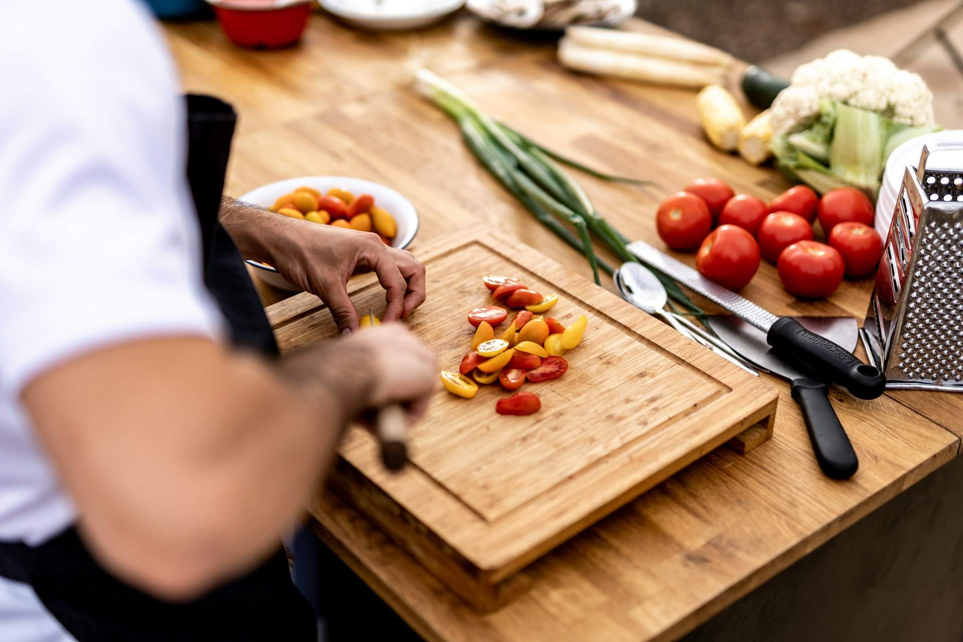 Chef chopping tomatoes on cutting board by Or Hakim on Unsplash